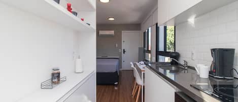 Una cocina compacta equipada con estufa integrada, cafetera y microondas.