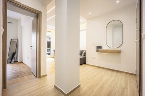 Ein modernes Interieur mit Holzboden, einem großen Spiegel und minimalistischem Design.
