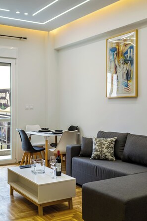 Ein modernes Wohnzimmer mit einer Couch, einem Couchtisch und einem Essbereich mit Stühlen und einem Tisch.
