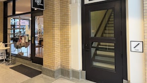 A storefront with a sign reading 'Dance Joy Studios,' a brick wall, a black door with a glass panel, and a 'Stairs' sign. - Local Discounts!-The Historic Newark Arcade (Newark)