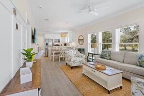 Ein modernes Wohnzimmer mit einer Couch, einem Couchtisch und einem Essbereich mit Stühlen und Tisch.