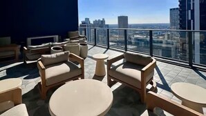 A rooftop terrace with outdoor seating, a clear view of the city skyline, and a modern building with a visible sign. - Lux Studio on 36th floor, Rooftop Pool, Prime Area (Miami)