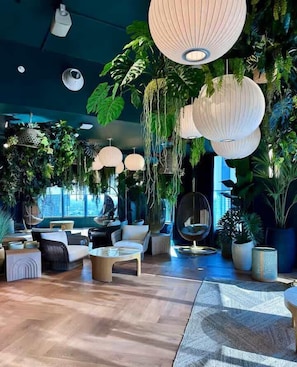 A modern lounge area with hanging paper lanterns, comfortable seating, and lush indoor plants. - 501 Residences Lux 1BR - New Unit - Top Location! (Miami)