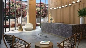 Un área de recepción moderna con mostrador, asientos y ventanas amplias.
