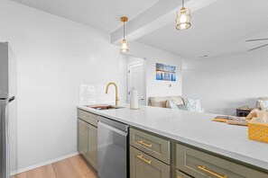 A modern kitchen with a white countertop, stainless steel appliances, and gold fixtures. - Renovated Condo near Silver Dollar City w Table Rock Lake View_Free Attraction Tickets_Private Deck (Branson)