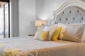 A neatly made bed with a patterned bedspread and multiple pillows, a bedside lamp, and a headboard. - Renovated Condo near Silver Dollar City w Table Rock Lake View_Free Attraction Tickets_Private Deck (Branson)