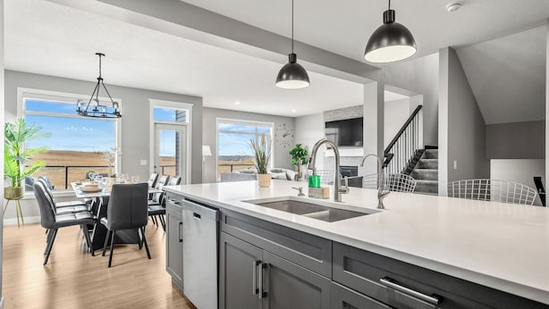 A modern kitchen with a large island, stainless steel appliances, and a view of the outdoors.