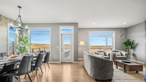 A spacious living area with a dining table, chairs, a sofa, and a coffee table.