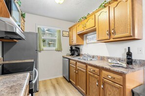 A kitchen with wooden cabinets, a stainless steel refrigerator, a coffee maker, and a sink. - Near Table Rock Lake & Sdc_Daily Free Tickets_Seasonal Cmty Pool/Hot Tub_Peaceful Deck (Branson)