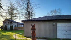 A residential area with a garage, a wooden sculpture, and a house with a sloped roof. - Sunset spectacular with resort amenities (Kawartha Lakes)