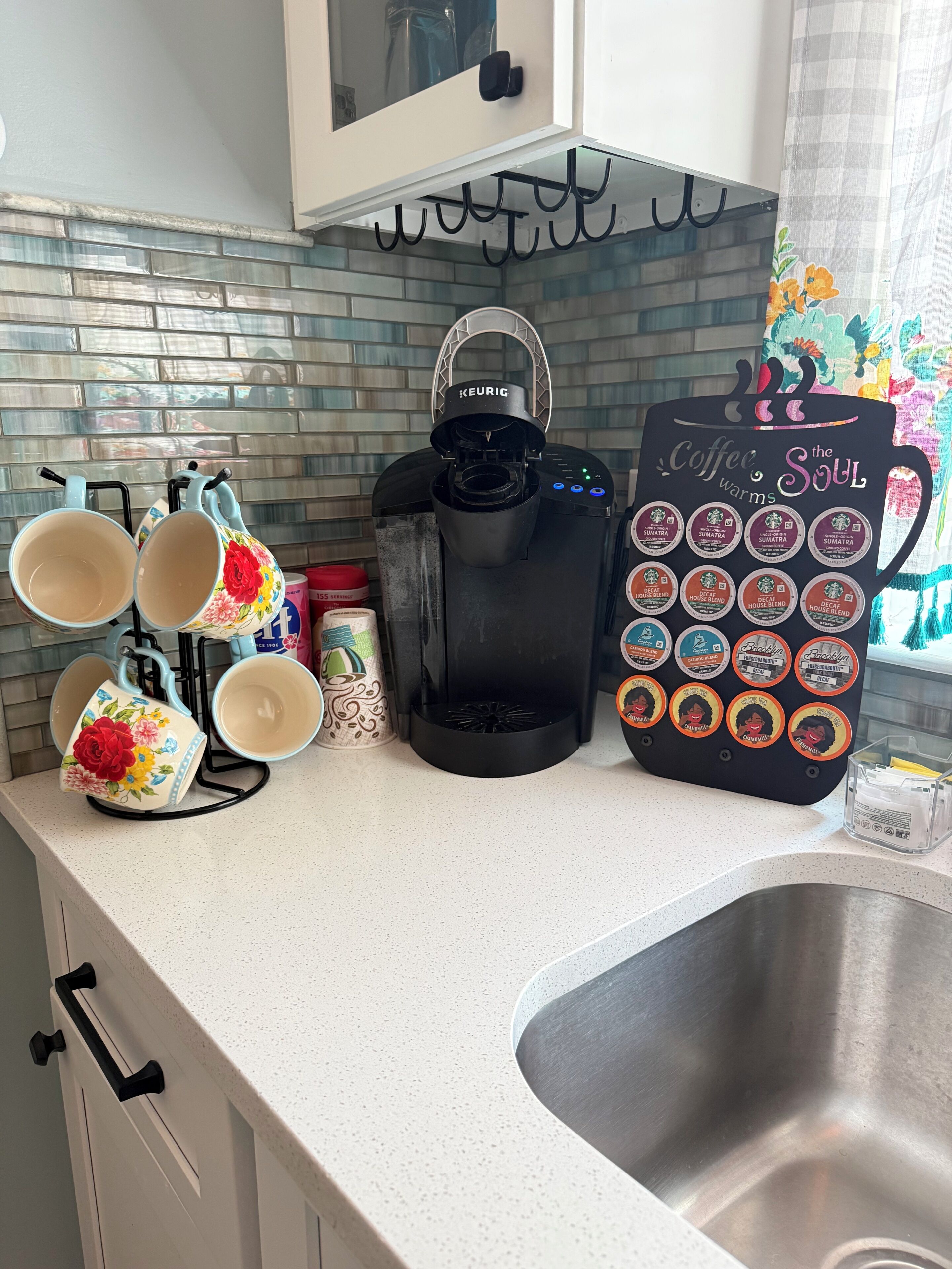 Un piano di lavoro in cucina con una macchina per il caffè Keurig, un portabicchieri e una tazza da caffè.