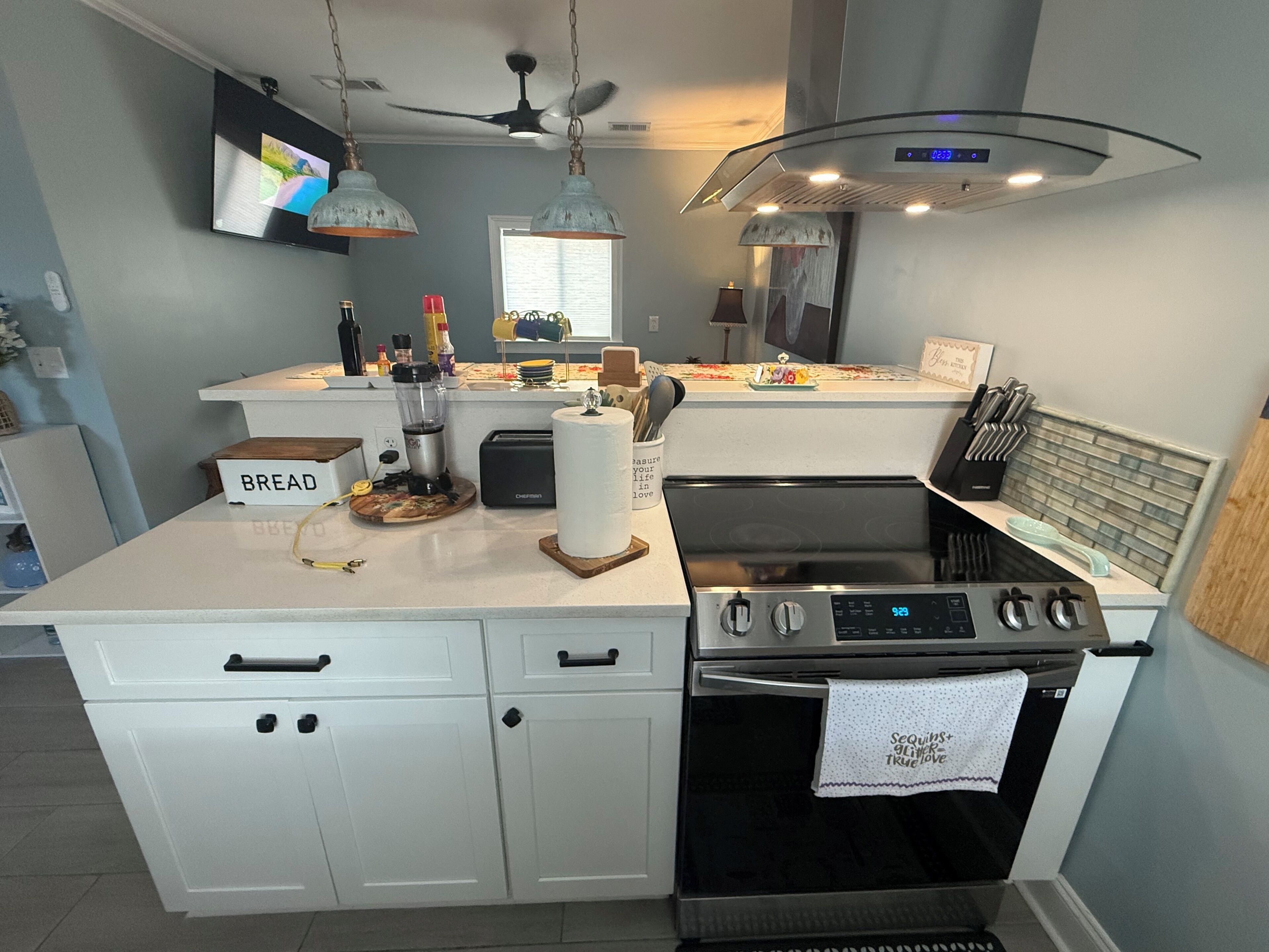 Een moderne keuken met een centraal eiland, een inbouwoven en een kookplaat.
