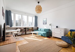 A modern living room with a desk, sofa, and a large window. - Plac Wilsona Charming Apartment (Warszawa)