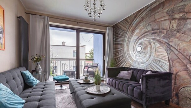 A modern living room with a large spiral staircase, a sofa set, and a dining table.