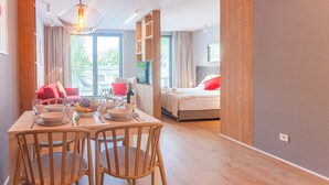 Et moderne hotelværelse med spiseplads, seng og fjernsyn.
