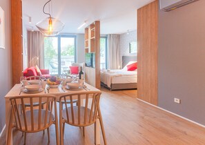 A modern hotel room with a dining area, a bed, and a TV. - Sopot City Comfort Apartment #1 (Sopot)