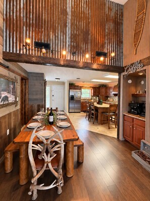 A spacious kitchen with a wooden dining table, chairs, and a coffee bar. - Luxury 6th Floor Penthouse • Cabin Vibes + Space Needle & Downtown Views (Gatlinburg)