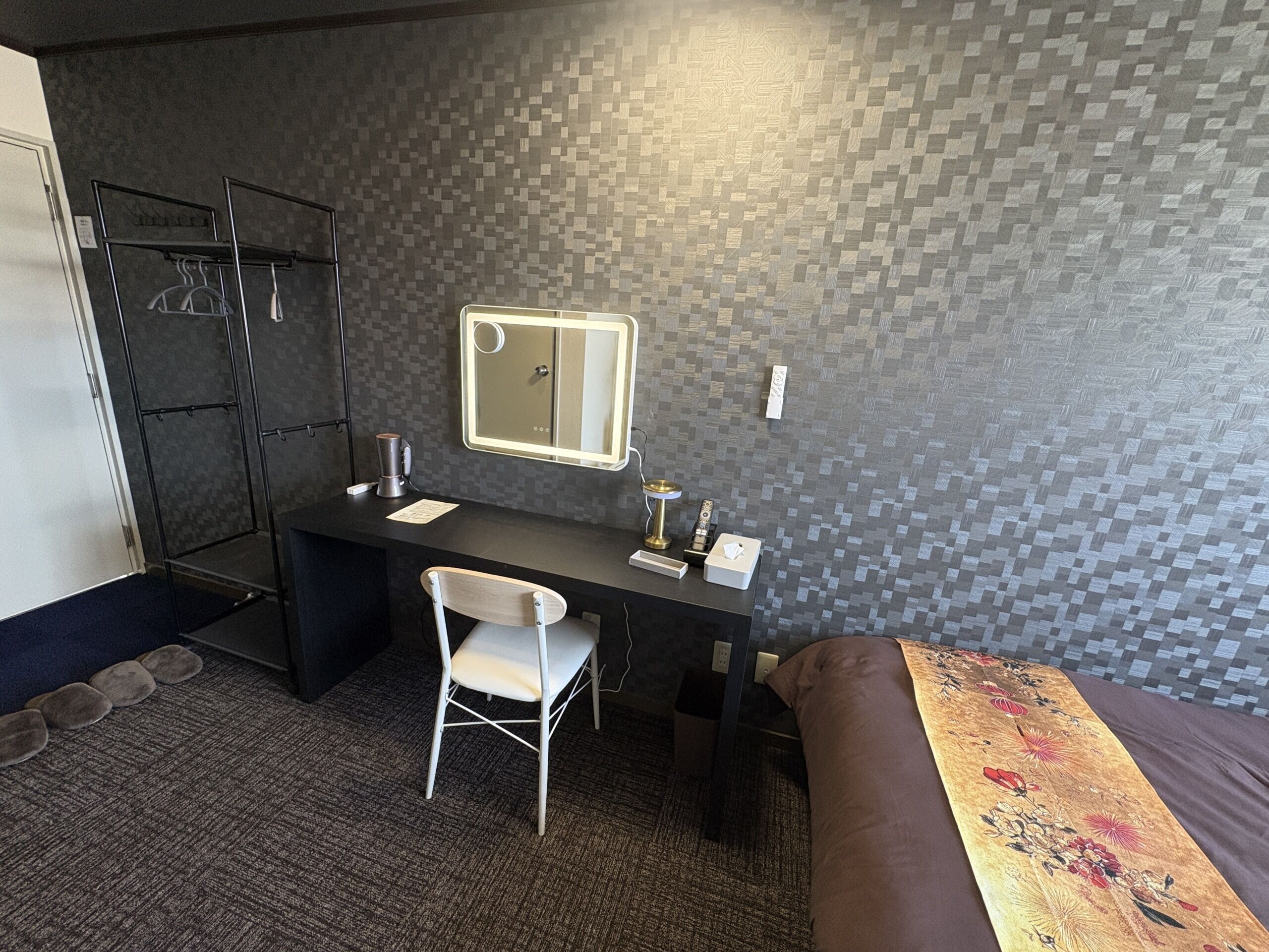 Une chambre d’hôtel équipée d’un bureau, d’une chaise, d’un lit et d’un espace douche.