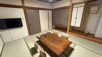 A traditional Japanese-style room with tatami flooring, a wooden table, and sliding doors.
