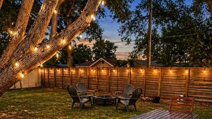 A wooden deck with a table and chairs, surrounded by a wooden fence and string lights. - Quiet Downtown Clermont Stay Near Waterfront Park (Clermont)