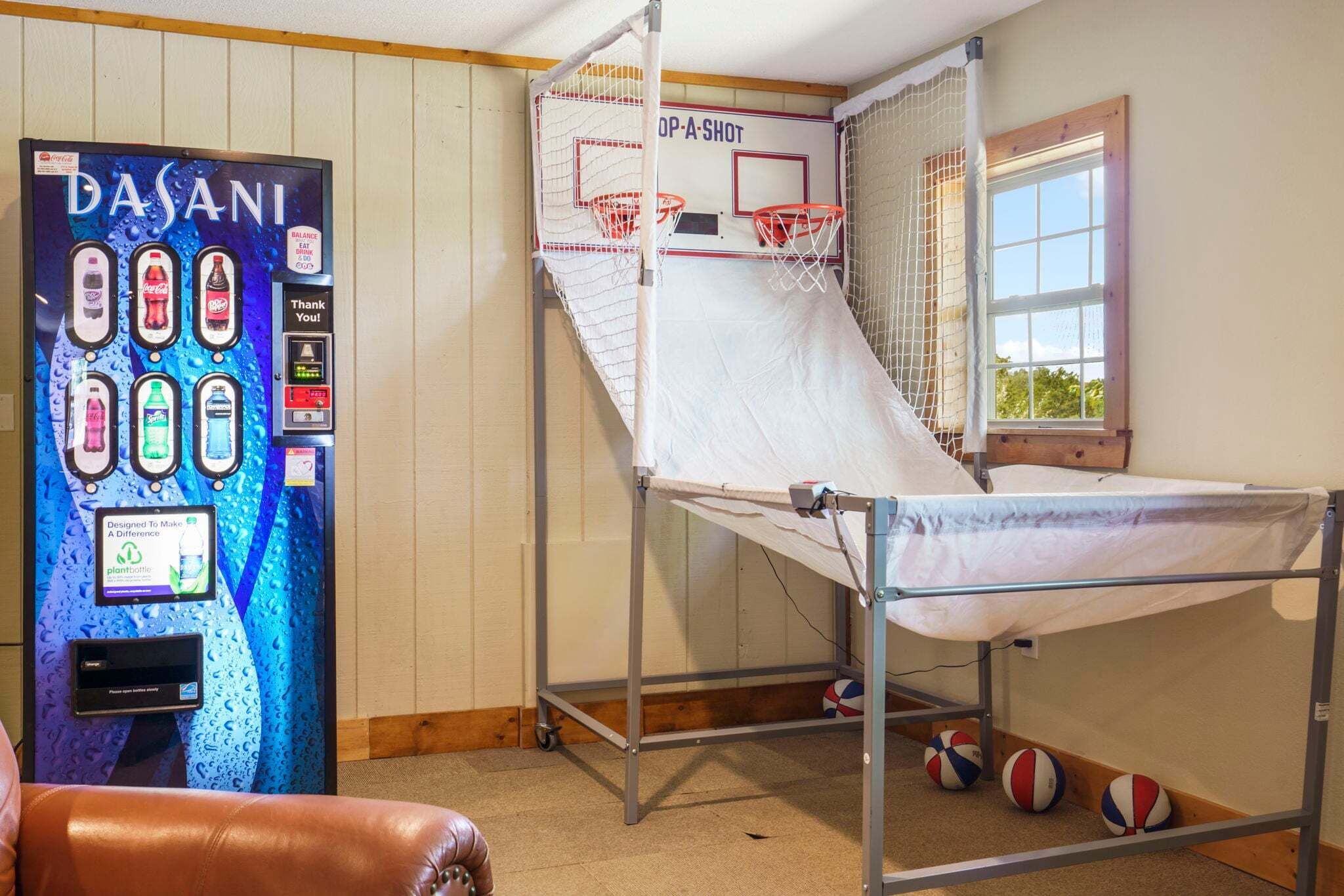 Een stapelbed met een basketballen, een DASANI waterdispenser en een raam met uitzicht.