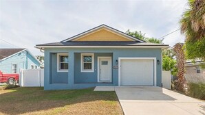 A single-story house with a garage, a front door, and a small porch. - The Oasis on Waters -New Home (Tampa)