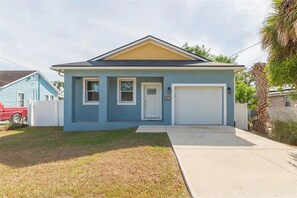 A single-story house with a garage, a front door, and a small porch. - The Oasis on Waters -New Home (Tampa)