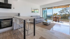Une cuisine moderne avec un coin repas, un canapé et un balcon offrant une vue agréable.