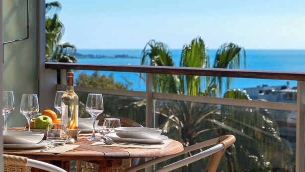 Une table dressée pour le dîner, avec vue sur l’océan.