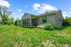 A single-story house with a large front porch, a covered entryway, and a screened porch. - Relaxing Barnstable Getaway Close to the Beach (Barnstable)