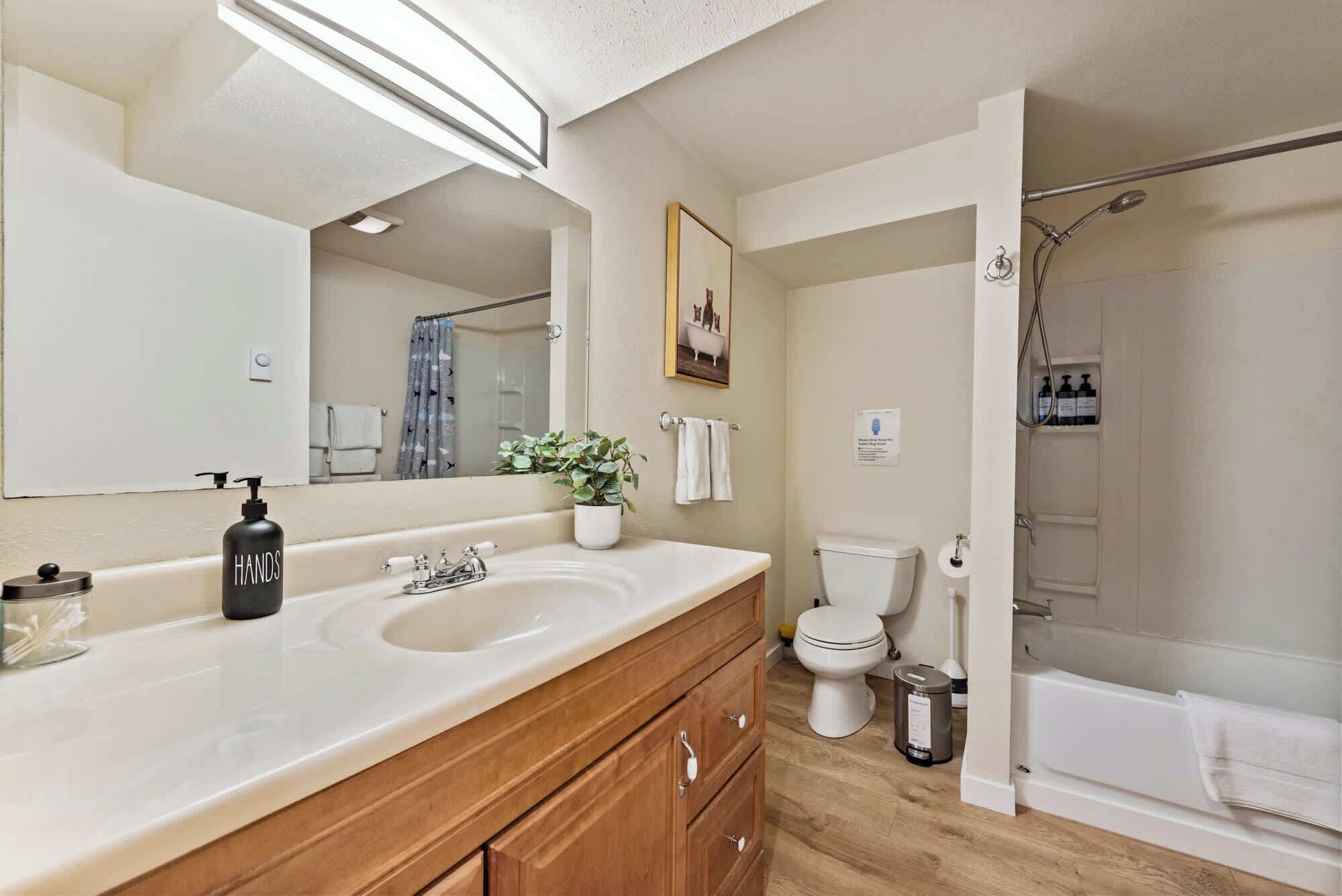 Ein Badezimmer mit Doppelwaschbecken, Toilette, Dusche und Spiegel.