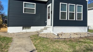 A two-story house with a dark exterior, white trim, and a front porch with steps leading to the door. - Centrally located newly renovated 2  bungalow in Lafayette. (Lafayette)