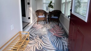 A hallway with a patterned rug, wicker chairs, a potted plant, and a ceiling fan. - Centrally located newly renovated 2  bungalow in Lafayette. (Lafayette)