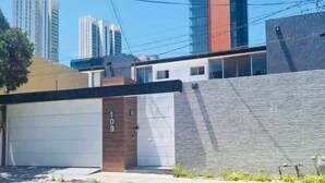 A modern building with a garage door, a brick wall, and a water feature.