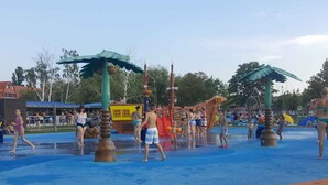 Un parque acuático con múltiples estructuras de juego, incluyendo toboganes y fuentes.