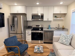 A modern kitchen with white cabinets, stainless steel appliances, a built-in microwave, and a coffee maker. - Full House • Walk to Beach • Families & Groups • Patio & Fire Pit • Parking (Myrtle Beach)
