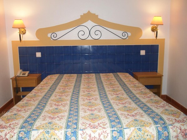 A hotel room with a bed, two bedside tables, a telephone, and wall-mounted lamps. - Hotel Passagem Do Sol (Moura)