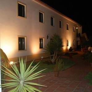 A building with multiple windows and a paved courtyard. - Hotel Passagem Do Sol (Moura)