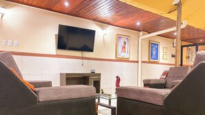 Una sala de estar moderna con un televisor de pantalla plana, asientos cómodos y una chimenea.