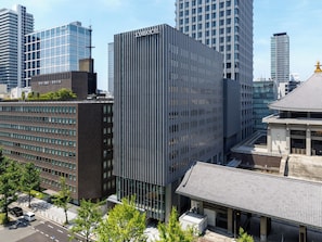 Un bâtiment moderne, sur lequel on peut voir une enseigne bien visible indiquant «Solaria Hotel», entouré d’autres immeubles de grande hauteur.