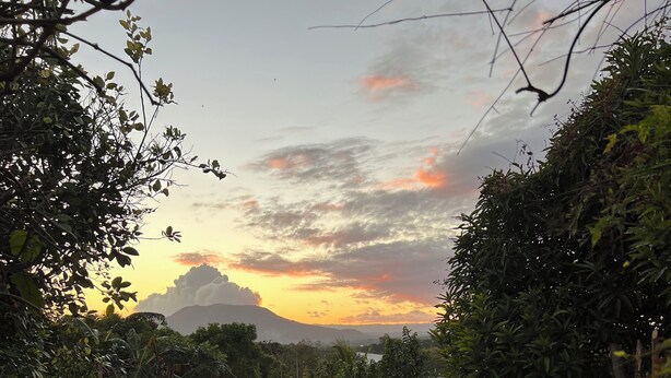 A patio with chairs, a table, and a view of the sunset. - Quaint 1-bedroom country house in tranquil farm (Masaya)