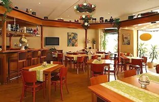 Restaurante com mobiliário de madeira, área de bar e um quadro na parede.