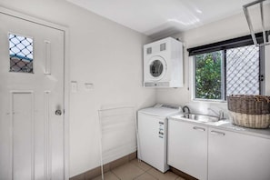 A laundry room with a washing machine, dryer, and a sink.