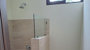 A bathroom with a shower, toilet, and a window. - 2-bedroom bed & breakfast in charming Cancun with AC (Cancun)