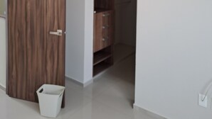 A room with a wooden wardrobe, a white trash bin, and a tiled floor. - 2-bedroom bed & breakfast in charming Cancun with AC (Cancun)
