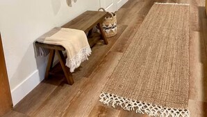 A hallway with a bench, a rug, a coat rack with a towel, and a door. - Ranchito Robles, Hot Tub • Fire Pit • Wine Country Retreat (Paso Robles)