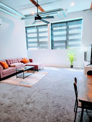 Uma sala de estar moderna com sofá, mesa de centro e área de jantar.