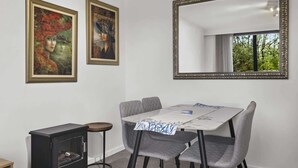Ein Essbereich mit Tisch, Stühlen, einem Spiegel und zwei Bildern an der Wand.