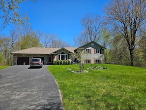 A two-story house with a garage, a driveway, and a well-maintained lawn.