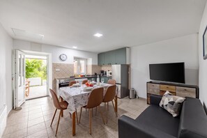 A modern apartment with a dining area, kitchen, and living space.